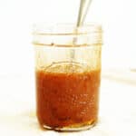 Jar with honey dip inside and spoon sticking out.