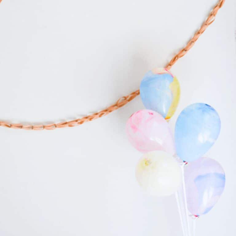 A party garland made with rubberbands next to balloons.