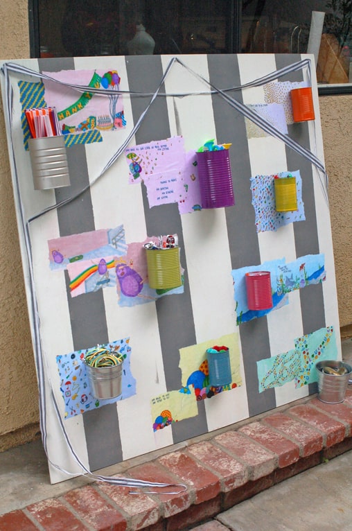 A large board with painted cans for a kid's party.