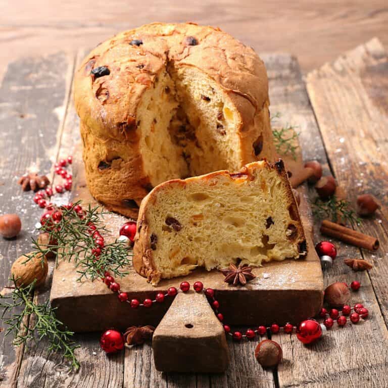 A panettone loaf with a piece cut out on a table.