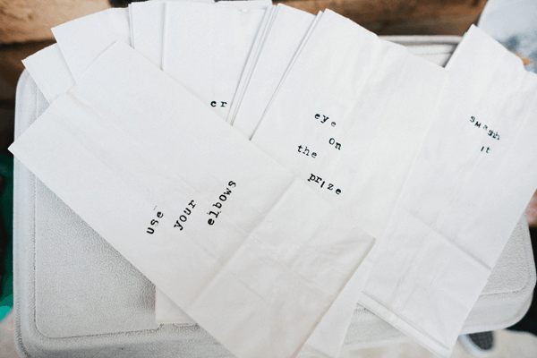 White lunch bags stamped with words. 