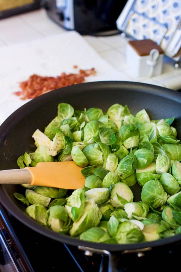 Chopped Brussels sprouts in a pan with a spatula. 