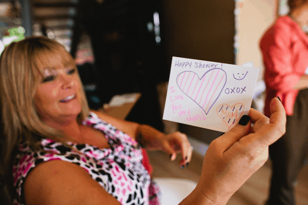 Woman holding a note with a heart on it.