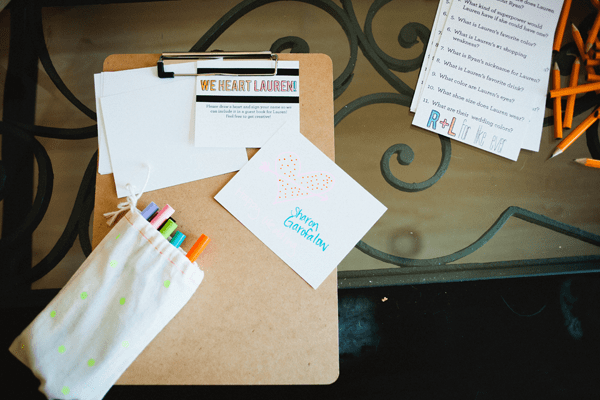 A clipboard with pens and notecards for the bride at a bridal shower. 