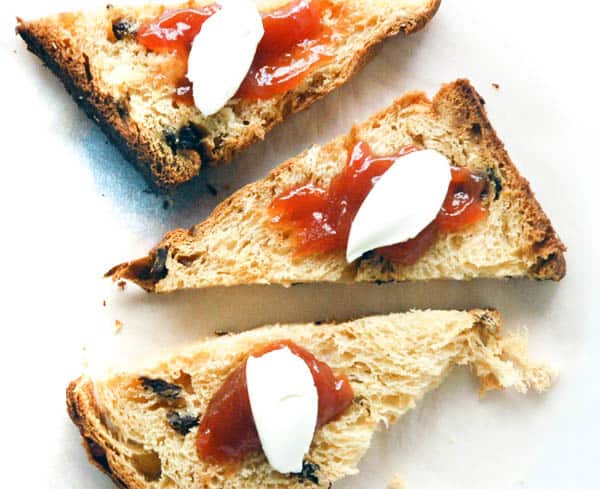 Small pieces of panettone on a table with jam and cream cheese. 