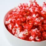 pink candy coated pop corn in a bowl