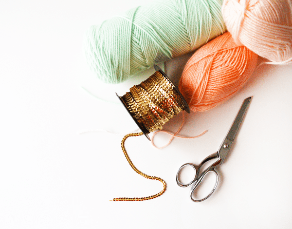 Mint and peach yarn plus gold sequin trim are all you need to get started with this tassel DIY.