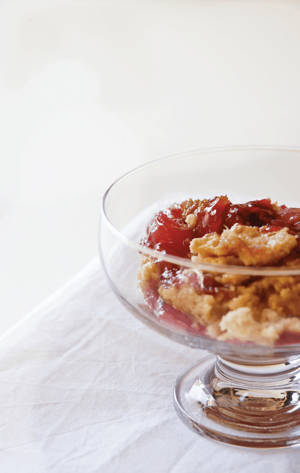 A serving of the best every Cherry Pineapple Dump Cake in a footed glass dessert bowl.