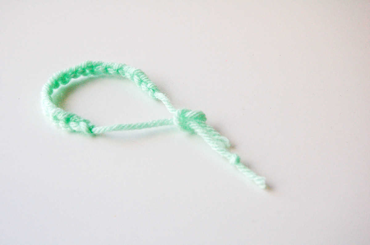Close up of a finished knotted yarn bracelet.