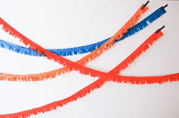 Fringed fabric garlands taped to a wall for a party decoration. 