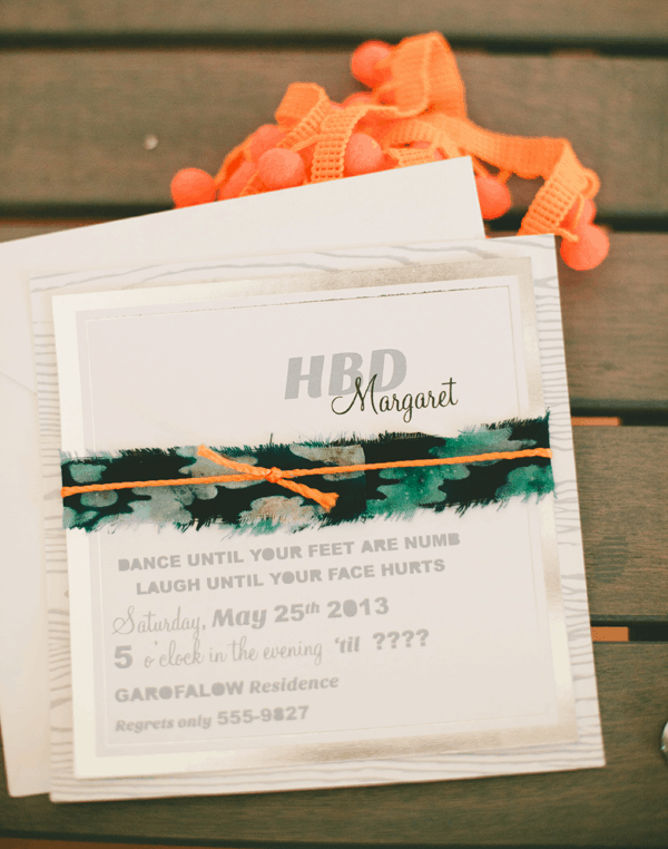 Custom adult birthday party invite from Carta Society wrapped with ikat fabric and an orange string.