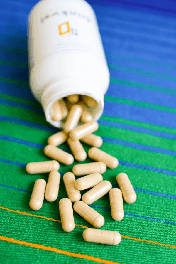 A bottle of Drinkwel laying on it's side with capsules spilling out. 