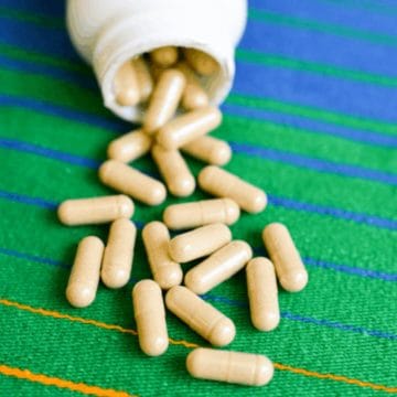 Supplement capsules spilling out of a bottle.