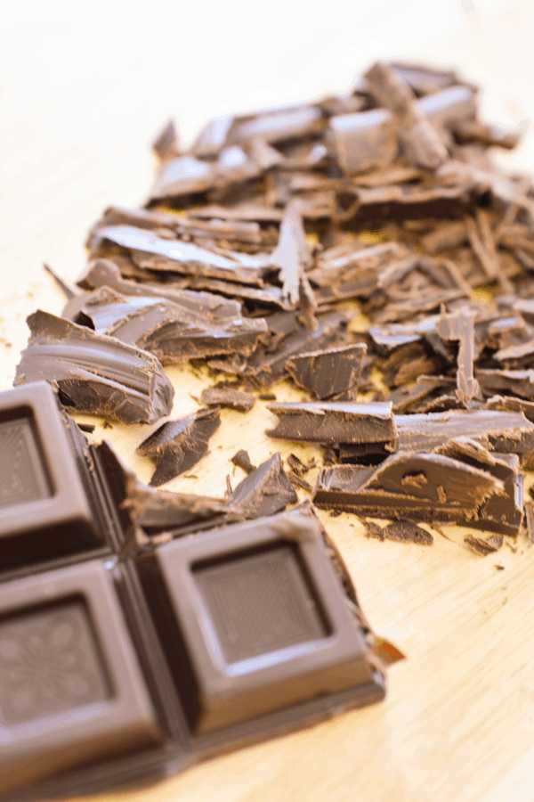 Chopped dark chocolate on a cutting board.