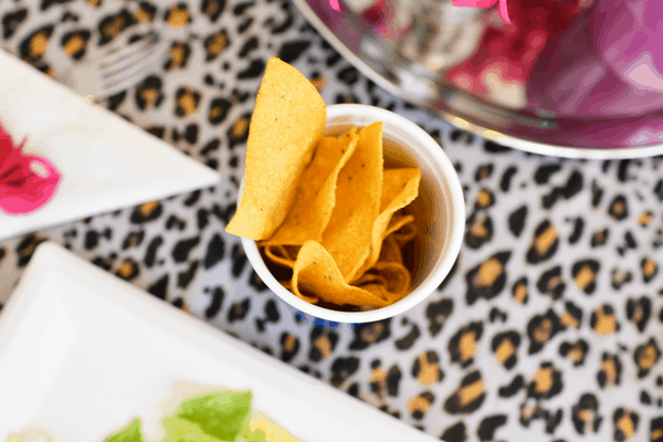 An overhead shot of a cup of tortilla chips on a table. 