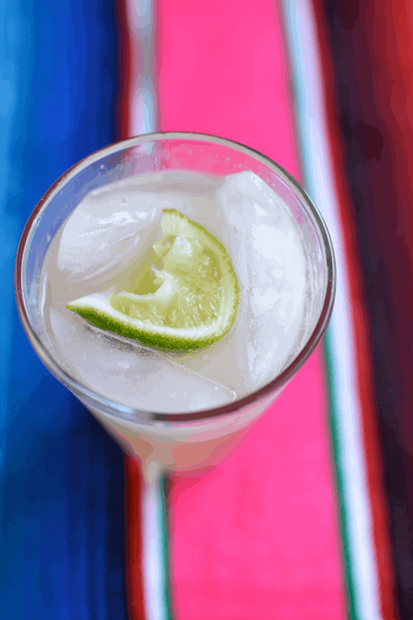 A tall glass full of ice and a Mexican Mule cocktail recipe with tequila and ginger beer.