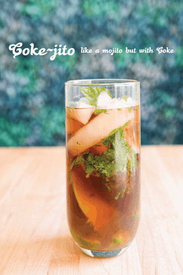 A mojito cocktail made with Coke in a glass on a table. 