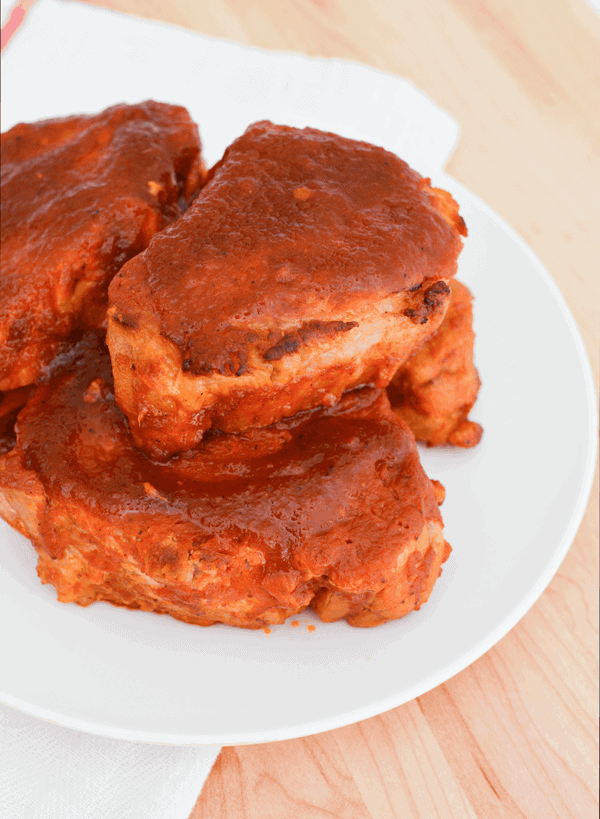 Close up of pork chops with sauce on them.