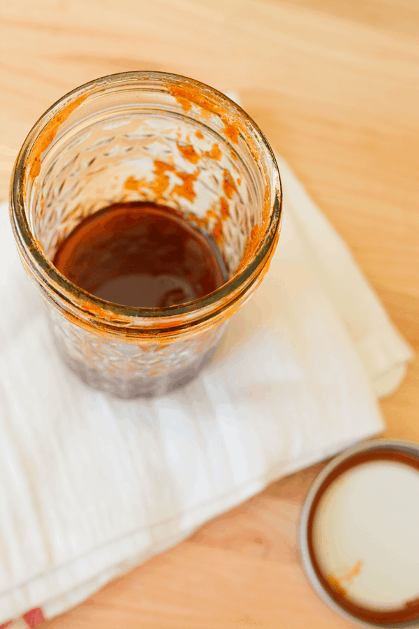 Jar of sauce on a cutting board.