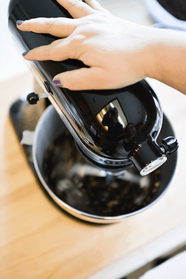 Woman's hand on top of a Kitchen Aid stand mixer.