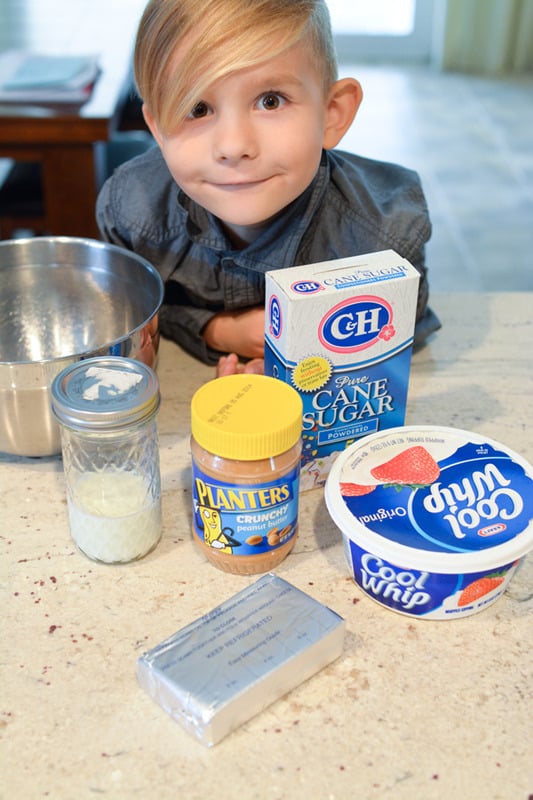 Little boy next to the ingredients to make a pie.