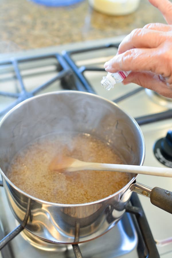 Adding cinnamon oil to a saucepan.
