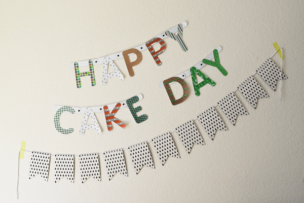 A DIY Minecraft birthday banner on a wall hanging above another banner for a party. 