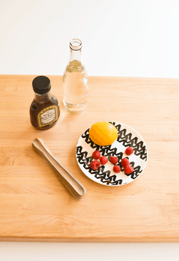 Ingredients for Muddled Raspberry Meyer lemon Lemonade on a wooden board.