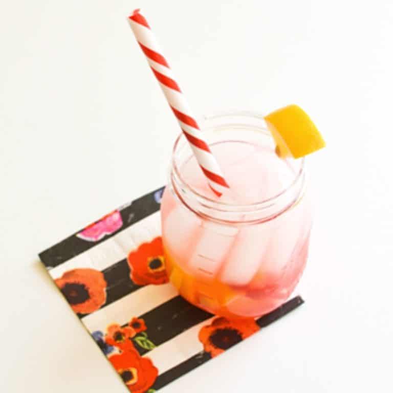 raspberry lemonade in a mason jar sitting on top of a floral napkin.