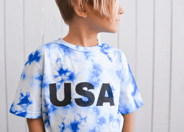 kid in blue and white tie dyed tshirt that says USA on it.