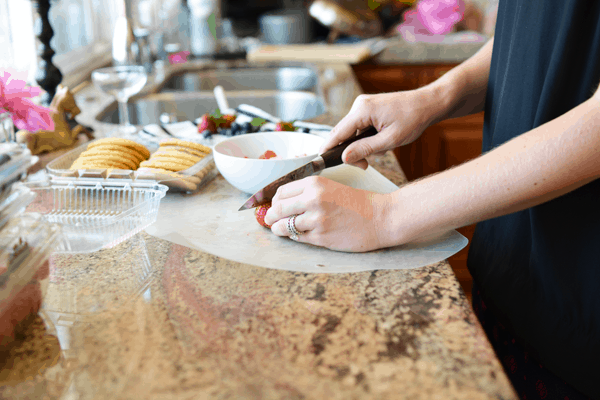 Woman cutting fresh berries at the kitchen counter.