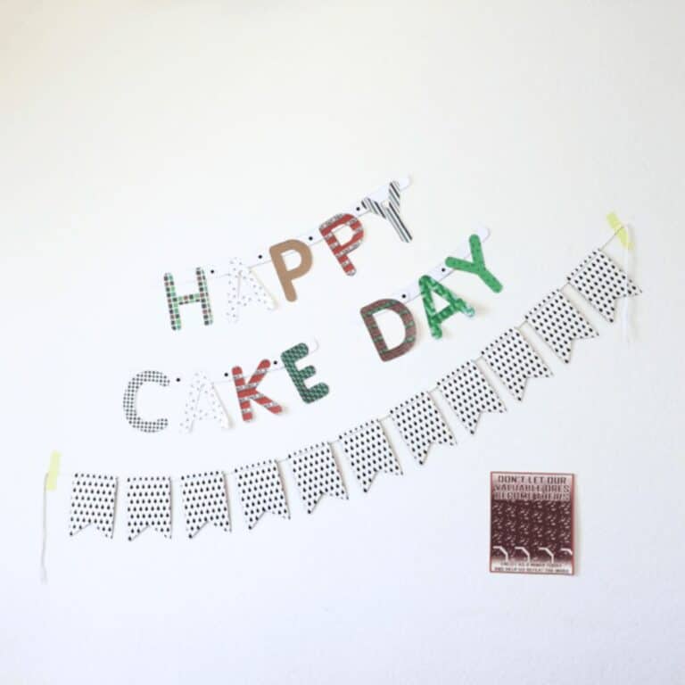 A party banner on a wall that says "Happy Cake Day" with letters using Minecraft themed papers.