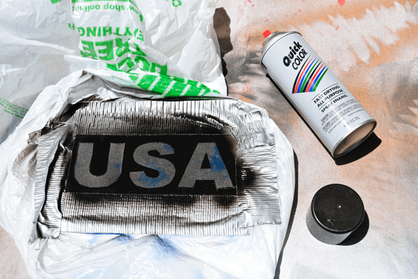 Spray painting a t shirt to say "usa" for 4th of july. 