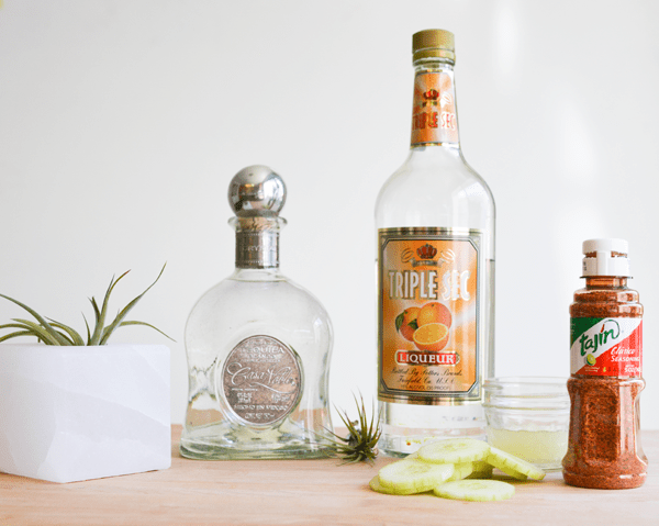 Ingredients for a cucumber margarita on a cutting board.