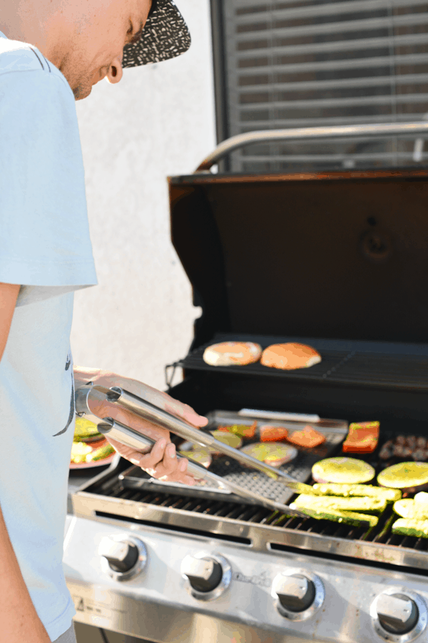 Man grilling vegetables on a barbecue.