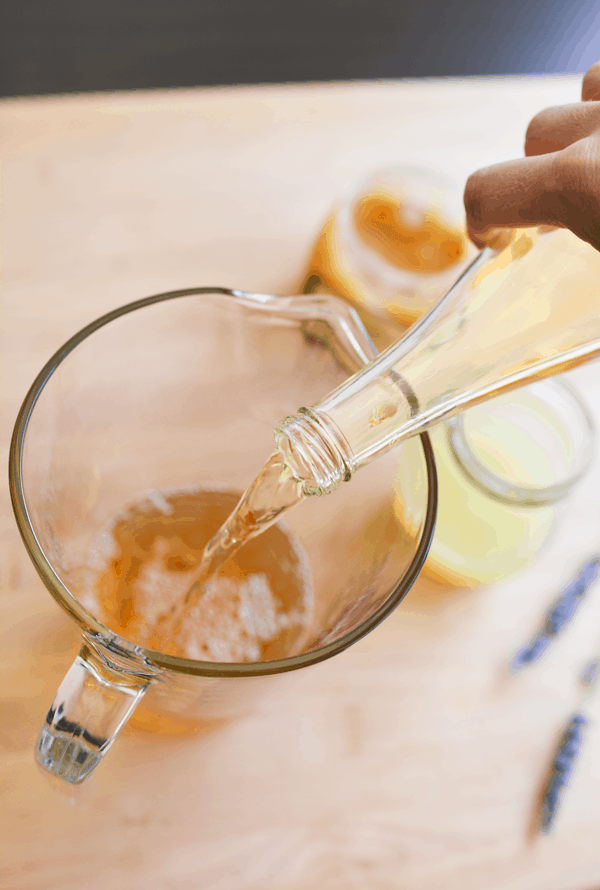 adding lavender tea to flavor homemade lemonade in a pitcher