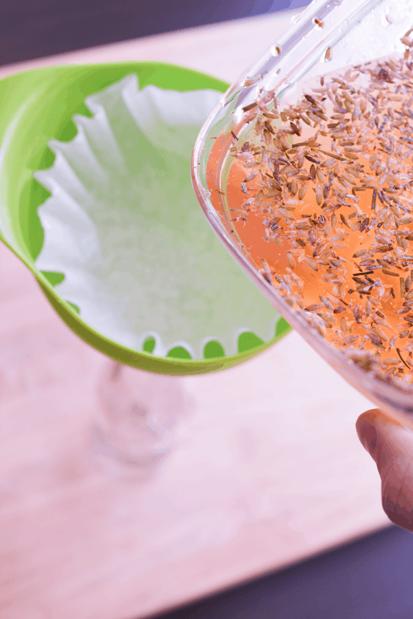 straining lavender tea through a coffee filter and funnel