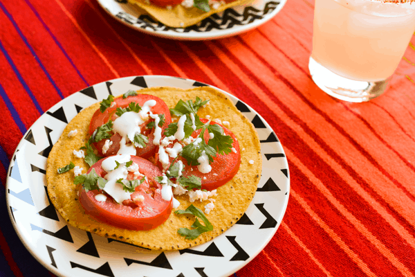 Mexican style caprese salad on a tostada on a plate. 
