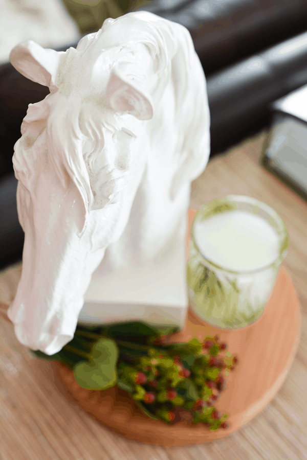 Horse statue next to pine candle to talk about holiday decor