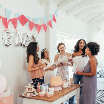 Woman standing around a table at a baby shower.