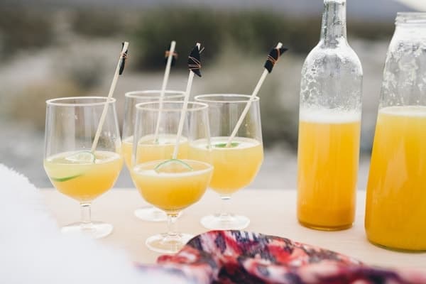 Delicious citrus champagne punch in glasses and bottles on an outdoor table. 