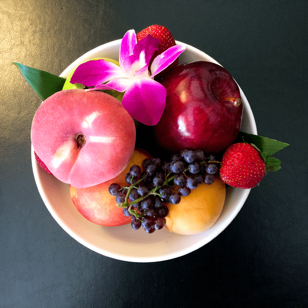 A pretty fruit bowl with orchid as a way to make mom feel special on Mother's Day