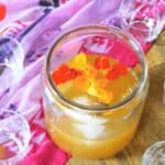 A glass of tiki rum punch on top of a brightly colored cloth.