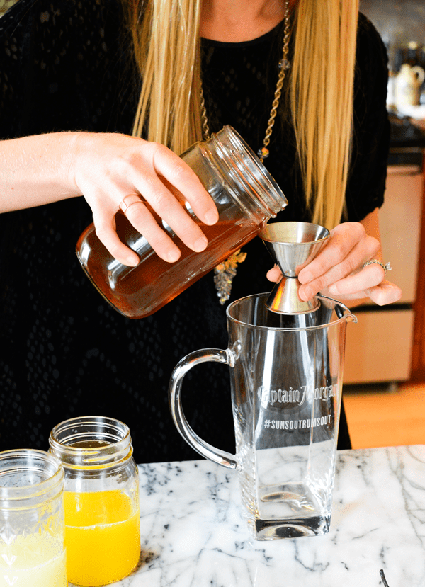 Vanilla and cinnamon simple syrup being measured into a pitcher.