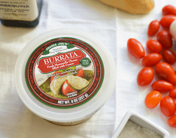 Burrata with tomatoes on a fabric to make a delicious appetizer.