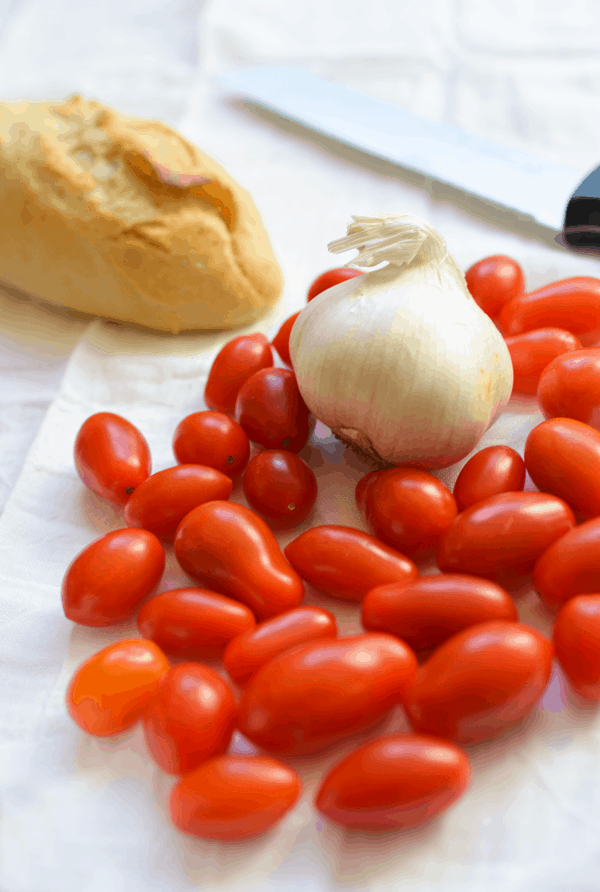 Cherry tomatoes and garlic to make a roasted cherry tomato with burrata appetizer recipe.
