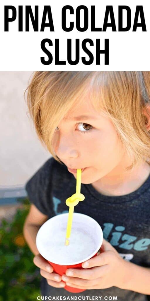 Close up of a kid drinking out of a bendy straw from a slushy in a red plastic cup.