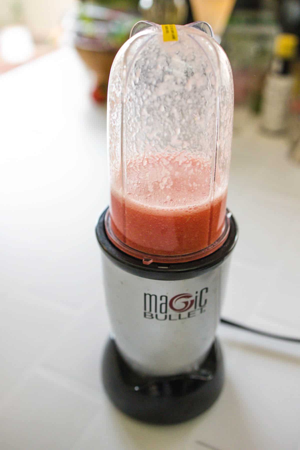 A magic bullet with freshly blended watermelon juice.
