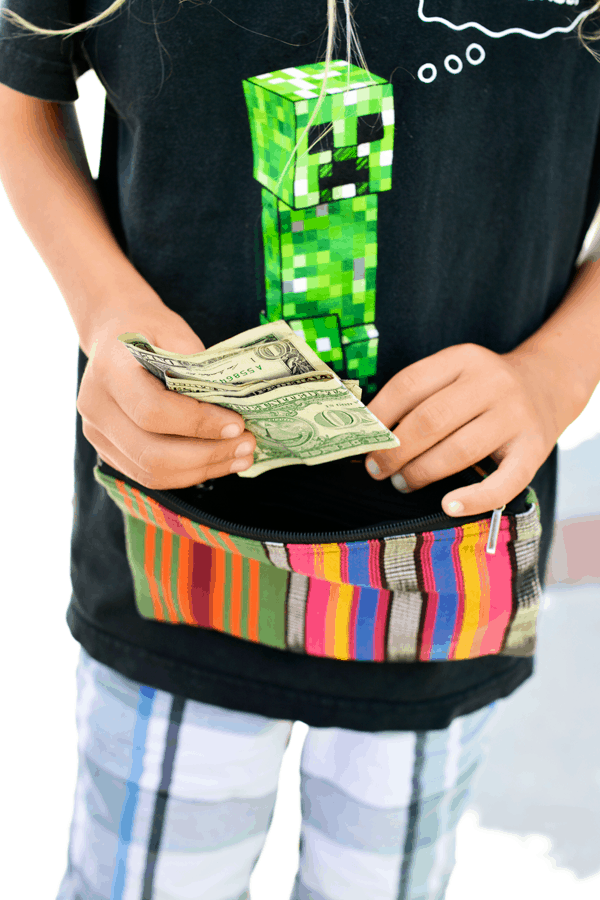 Kid holding a few dollar bills from a lemonade stand. 