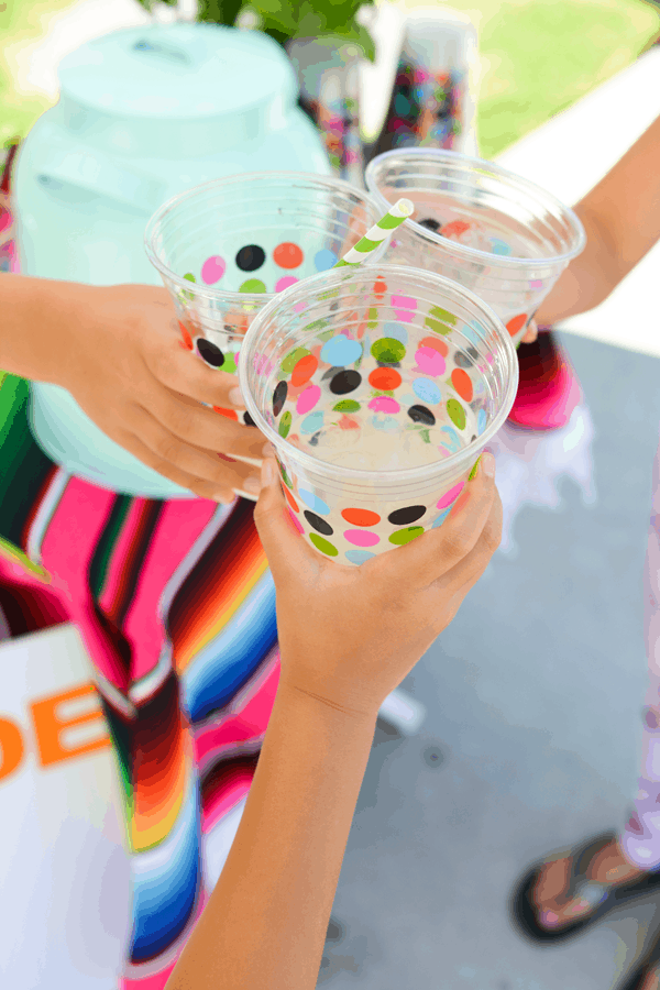 Kids clinking cups of lemonade.